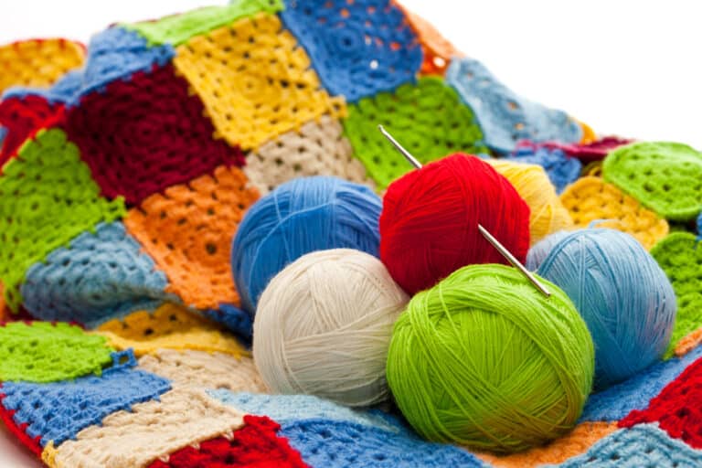 Colorful balls of yarn on crocheted blanket