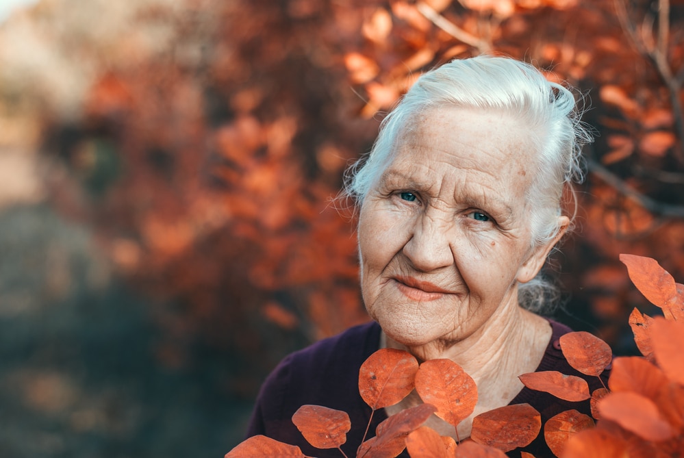 portrait of senior woman in fall leaves