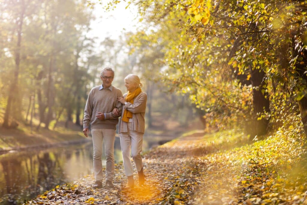 Senior couple walking outside in fall foliage