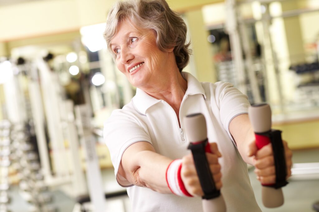 Smiling senior woman working out at the gym
