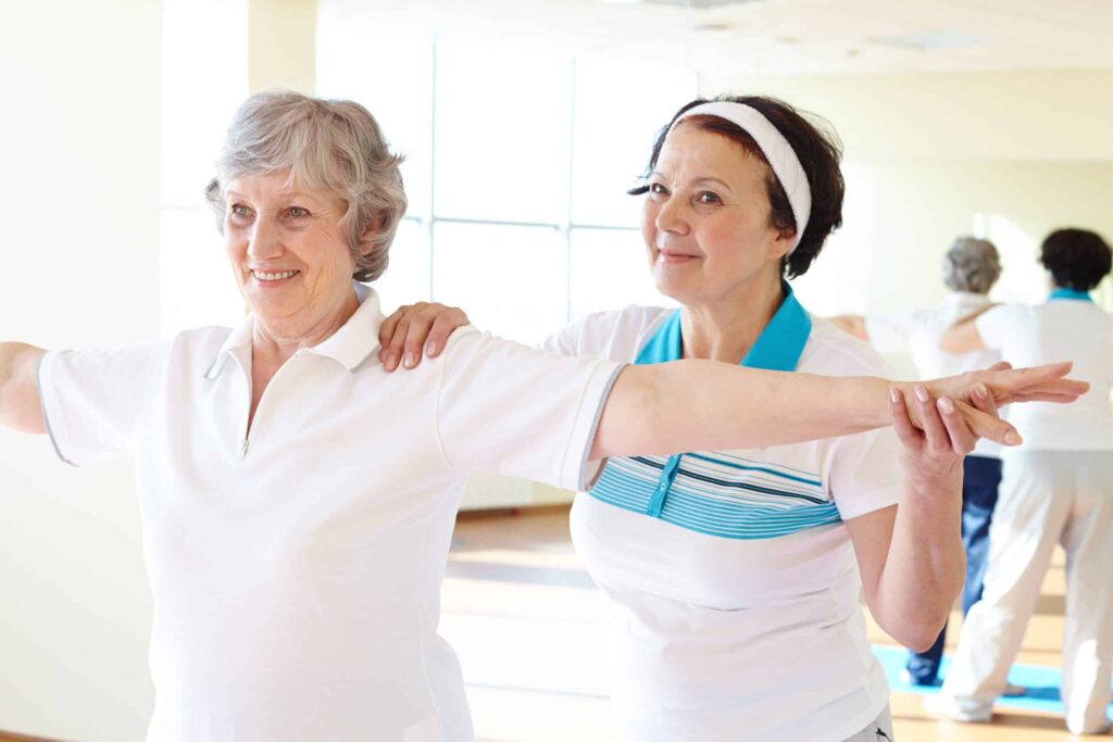 Senior-woman-doing-arm-exercises-with-assistance-scaled