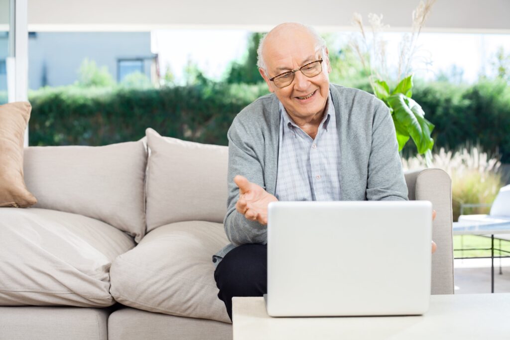 Senior man video chatting using laptop